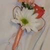 Small boutonniere with a white daisy and peach-orange flowers