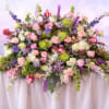 A lush and romantic garden-style arrangement overflowing with soft blush roses, delicate