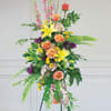 Tall floral standing arrangement with roses, lilies, and mixed blooms