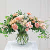 Peach and pink floral arrangement in a clear glass vase