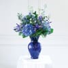 Blue and purple flower arrangement in a cobalt vase