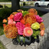 Bright mixed bouquet of pink, orange, and green flowers in a vase