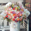 Large mixed bouquet in a white hat box with pink, orange, and white flowers
