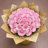 Bouquet of pink roses wrapped in patterned gold paper