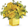 Yellow roses and lilies arranged in a square glass vase