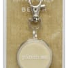 Packaged keychain with a round cream charm and metal clip