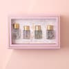 Pink gift box with four small perfume bottles inside