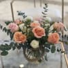 Peach and blush roses mingle with delicate ranunculus and little white blooms