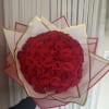 Large bouquet of red roses wrapped in pink and gold paper