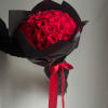 Bouquet of red roses wrapped in black paper with a red ribbon