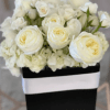 Creamy white roses set above a cloud of white hydrangeas create a