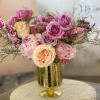 Soft blush roses mingle with lavender, cream, and peach blooms in this