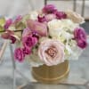 A compact cluster of blush, white, purple and peach blooms in a