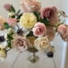 A lush cluster of blush, cream, mauve and peach roses arranged with