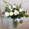 White roses and white ranunculus float above a cloud of mixed greenery