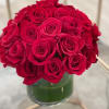 A dense, dome-shaped cluster of vivid red roses gives this flower arrangement