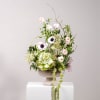 Tall floral arrangement in a pedestal bowl with pale pink and white blooms