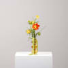 Small orange and yellow flower arrangement in an amber vase