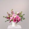 Pink and white roses arranged in a white cylindrical vase