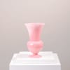 Pink glass vase on a white pedestal