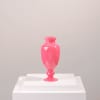 Bright pink glass vase on a white pedestal