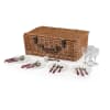 Wicker picnic basket with plates, cutlery, and wine glasses