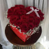 Heart-shaped box filled with red roses and baby's breath