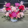 A lush, romantic arrangement featuring peonies, roses, and complementary filler blooms, accented