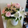Pink roses and white lilies in a white vase