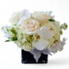 White and blush bouquet with roses and orchids in a black vase