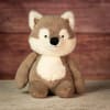 Plush wolf toy sitting against a wood backdrop