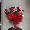 Red roses in a glass vase with a large red bow