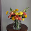 a variety of blooms including ranunculus, roses and carnations in a bright