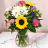 This floral arrangement is bright and joyful, featuring bold yellow sunflowers as