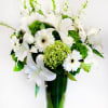 White lilies and gerbera daisies in a green glass vase