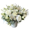 White floral arrangement in a pale vase with roses, calla lilies, and orchids