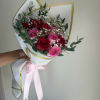 Bouquet of red and pink roses wrapped in white paper with a pink ribbon