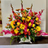 Large colorful floral arrangement in a white container