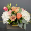 A romantic combination of peach roses, pink tulips, and delicate textures, designed