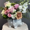 A sweet and delicate arrangement featuring soft pink blooms, creamy accents, and