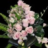 Soft pink roses and pale pink alstroemeria form the heart of this