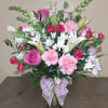 A lush, rounded sympathy arrangement in soft pinks, whites and gentle greens