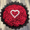 Round bouquet of red roses with a white heart accent
