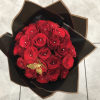 Bouquet of red roses wrapped in black paper with a gold butterfly accent