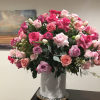 Large bouquet of pink and lavender roses in a white vase