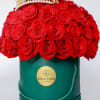 A dense dome of vivid red roses crowned with a gold-toned decorative