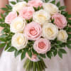 A romantic blend of soft blush and ivory roses, elegantly arranged with
