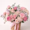 Pink and cream rose bouquet in a woven basket with ribbon