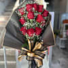 Bouquet of red roses with baby's breath and a black-and-gold ribbon