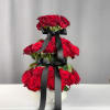 Tiered arrangement of red roses with black ribbon in a white box